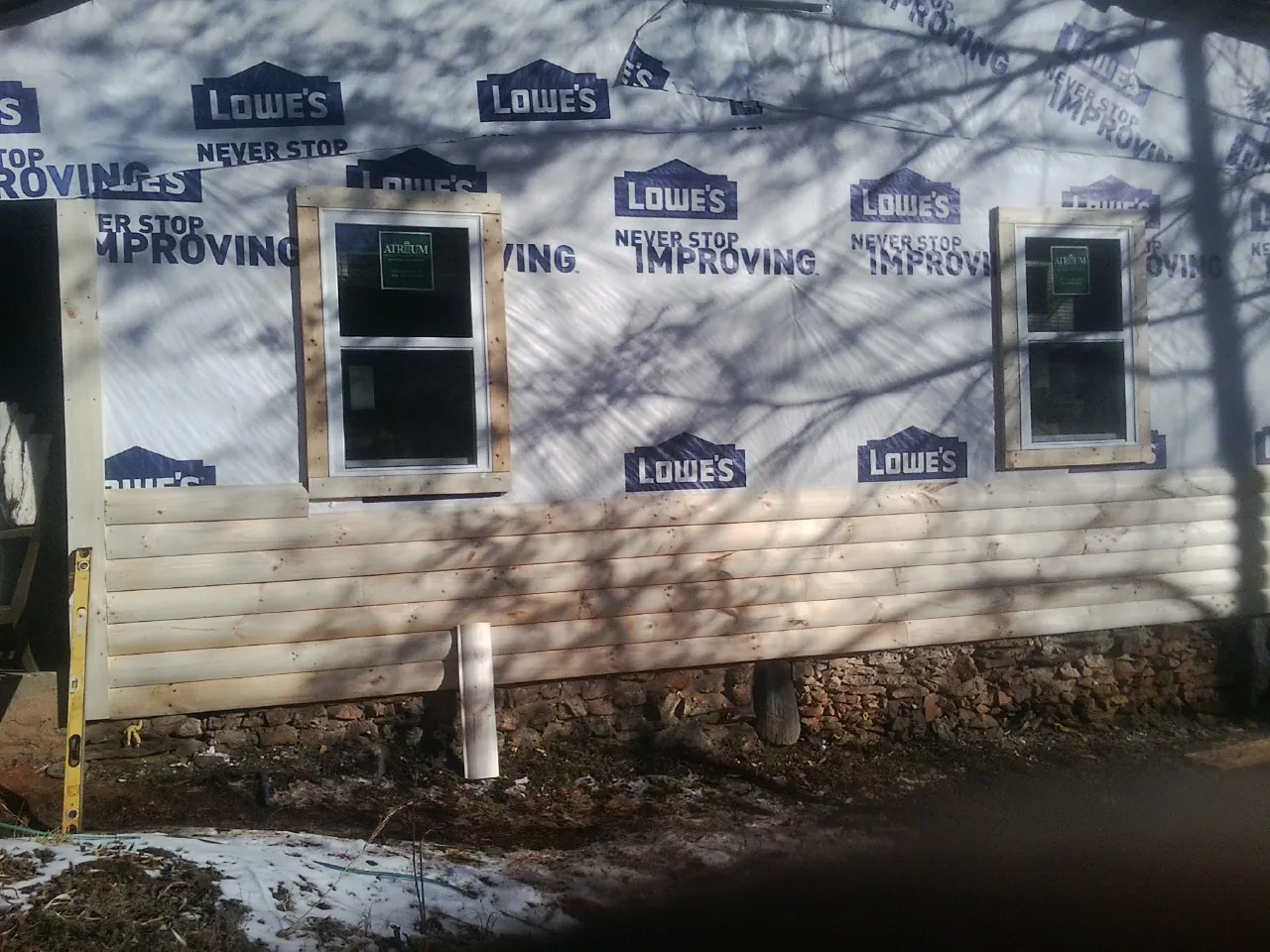 House wrap and new log siding going up on an exterior wall in North Reading