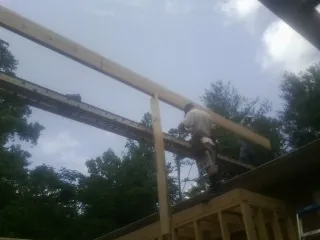 Carpenter setting a ridge beam over a new addition frame — Ice Dam Removal by Roofing Brothers in North Reading