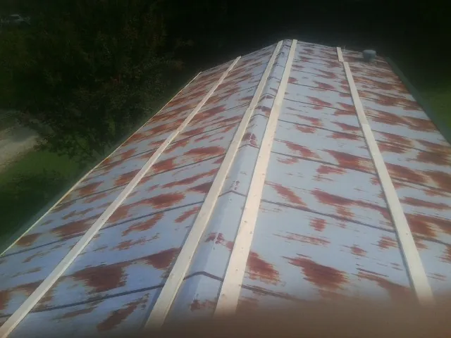 Rusted metal roof panels with new wood purlins before replacement — Storm Damage Roof Repair in North Reading by Roofing Brothers
