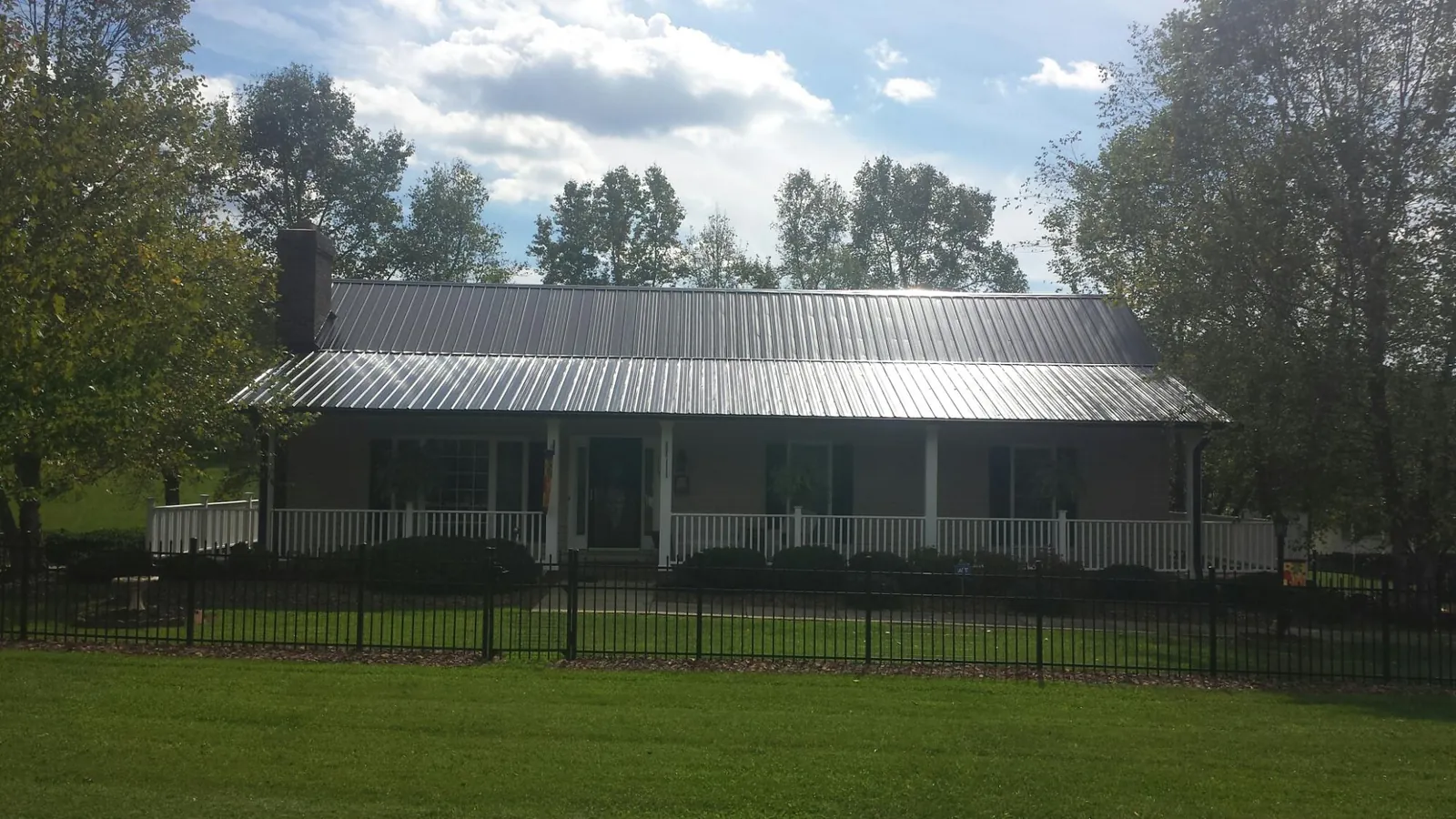 Gray metal roof on a brick ranch with a full width front porch — Gutter Guard Installation work by our crew in North Reading